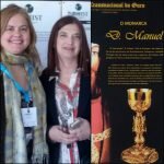 La Dra. Claudia Henriques directora de la Comisión Organizadora de TURHIST 2019 junto con la Dra. Ana Mafé experta en el Santo Grial. La imagen contigua es un póster sobre la Ruta del Oro en Évora.